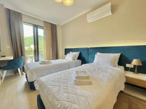 a hotel room with two beds and a window at Comfort Apartments Pasha in Budva