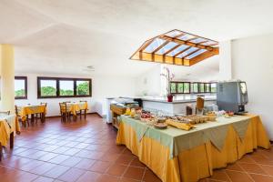 a large kitchen with a table with food on it at Hotel Petri Marini in Aglientu