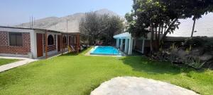 a yard with a swimming pool next to a house at Hotel Quilla Wasi in Lunahuaná +59 photos