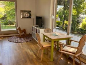 uma sala de estar com uma mesa e cadeiras e uma televisão em Atelier Seeshaupt em Seeshaupt