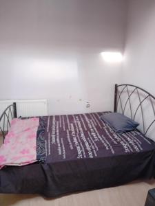 ein Schlafzimmer mit einem Bett mit einem schwarzen Metallrahmen in der Unterkunft ΜΕΖΟΝΈΤΑ in Síndos