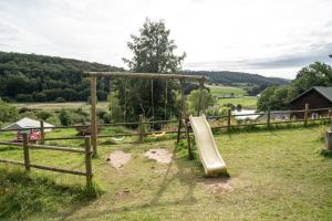 a playground with a slide in a field at Gite de 4 mitoyen 2 plus 2 Fécamp Etretat in Colleville
