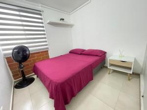 1 dormitorio con cama rosa y ventana en TIM HOUSE, en Jamundí