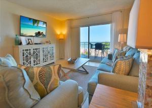a living room with couches and a view of the ocean at Beachfront Madeira Norte in St Pete Beach