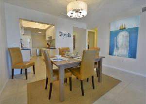 a dining table and chairs in a living room at Beachfront Madeira Norte in St Pete Beach