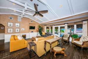 a living room with yellow furniture and a ceiling fan at Gulf Front Dreams in Clearwater Beach