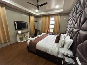 een slaapkamer met een groot bed en een flatscreen-tv bij Fair Mount in Srinagar
