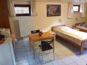 ein Schlafzimmer mit einem Bett, einem Tisch, einem Bett und einem Schreibtisch in der Unterkunft B & B Buchhorst 21481 in Buchhorst