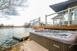 a hot tub on the side of a house on the water at Private waterfront cottage - hot tub & kayaks in Kingston