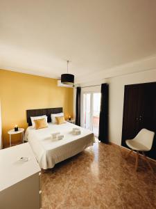 a bedroom with a large bed and a white chair at Alvor Apartment in Alvor