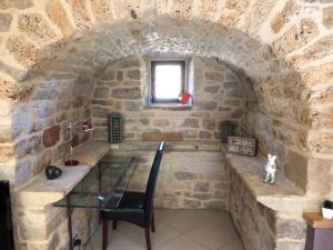 een stenen kamer met een tafel en een raam bij Gîte La Laiterie - La Planhe in Bozouls