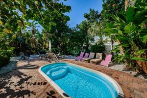 einen Pool im Hinterhof mit Stühlen und einem Tisch in der Unterkunft Sea Breeze Beach House in Clearwater Beach