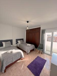 a bedroom with two beds and a purple rug at Alvor Apartment in Alvor