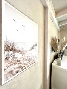 ein Flur mit einem Bild von einem Strand mit Vögeln an der Wand in der Unterkunft Alte Druckerei in Flensburg