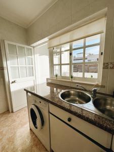 a kitchen with a sink and a counter top at Alvor Apartment in Alvor