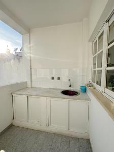 cocina blanca con fregadero y ventana en Alvor Apartment, en Alvor