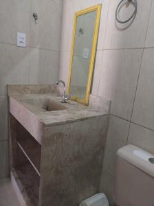 y baño con lavabo con espejo y aseo. en Cantinho do Relax en Vera Cruz de Itaparica