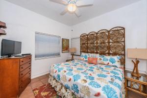 a bedroom with a bed and a flat screen tv at Su Casa in Clearwater Beach
