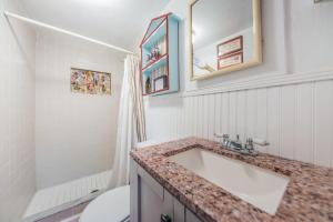 a white bathroom with a sink and a toilet at Su Casa in Clearwater Beach