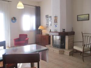 een woonkamer met een tafel en een open haard bij One Home ~ Fits All in Mouzákion