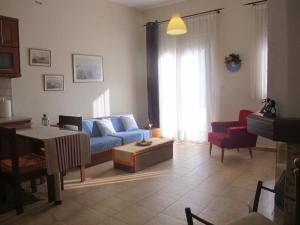 een woonkamer met een blauwe bank en een tafel bij One Home ~ Fits All in Mouzákion