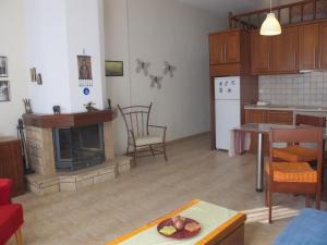 een woonkamer met een open haard en een keuken bij One Home ~ Fits All in Mouzákion