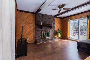 a living room with a brick fireplace and a couch at Gorgeous 5 Bedroom House in Brossard