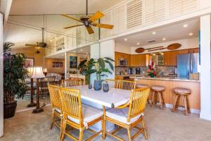 a dining room with a white table and chairs at MAKENA SURF, #G-304 condo in Wailea