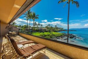 a balcony with chairs and a view of the ocean at MAKENA SURF, #G-304 condo in Wailea
