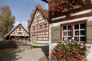 two pictures of a building with flowers on it at BnB-Home Apartment in Buxheim