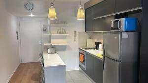 a kitchen with a stainless steel refrigerator and a microwave at Sissi Apart in Buenos Aires