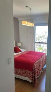 a bedroom with a large red bed with a window at Sissi Apart in Buenos Aires +29 photos