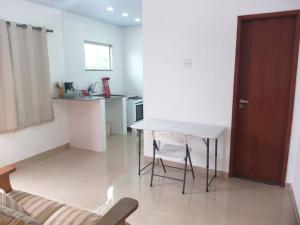 ein Wohnzimmer mit einem Tisch und einer Küche in der Unterkunft Casa tranquila 2 Q, bem localizada, ar opcional wifi grátis. in Araruama