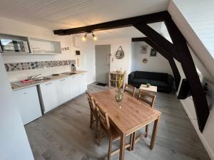 una cucina e una sala da pranzo con tavolo e sedie in legno di Studio centre ville le saint'oh a Saint-Omer