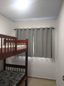 ein Schlafzimmer mit einem Etagenbett und einem Vorhang in der Unterkunft Casa tranquila 2 Q, bem localizada, ar opcional wifi grátis. in Araruama