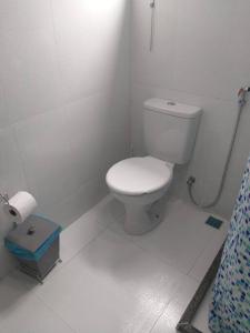 uma casa de banho com WC num quarto branco em Casa tranquila 2 Q, bem localizada, ar opcional wifi grátis. em Araruama