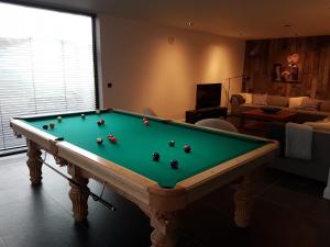 a living room with a pool table in a room at Vakantiehuis Hanna in Zedelgem
