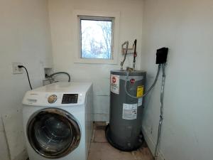 a laundry room with a washing machine and a window at Downtown Norfolk private room D1 in Norfolk