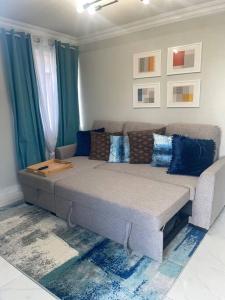 un soggiorno con un grande divano e cuscini blu di West View 2- T20 World Cup finals a Saint James