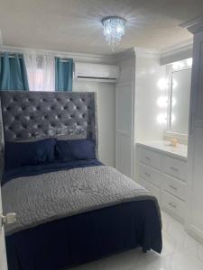 una camera con letto e piumone blu di West View 2- T20 World Cup finals a Saint James