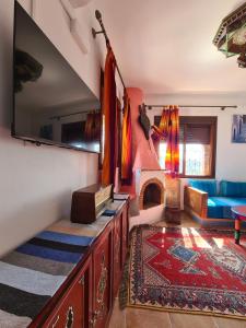 Casa Blue Star في شفشاون: غرفة معيشة مع أريكة ومدفأة