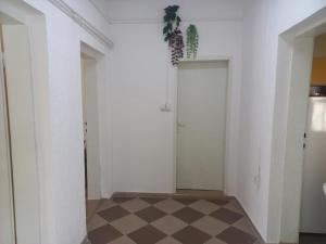 a hallway with white walls and a checkered floor at Веселый домик in Lazarevo