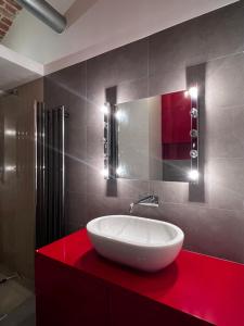 un bagno con lavandino bianco su un bancone rosso di Loft Apartment by Letrent a Żyrardów