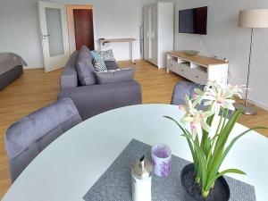 a living room with a white table and couches at Moderne Wohnung mit Vollausstattung in ruhiger Lage, W-LAN in Großröhrsdorf