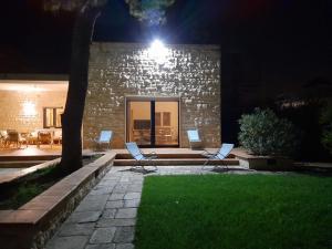 a couple of chairs sitting in a yard at night at Villa Rossi in Polignano a Mare