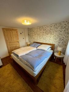 a bedroom with a bed with a blue comforter at Ferienhaus „Casa Lore“ in Frankenheim