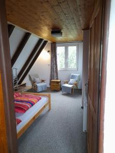 a bedroom with a bed and a chair in a room at Chaloupka na vršku in Loučná pod Klínovcem