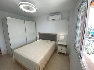 ein weißes Schlafzimmer mit einem Bett und einem Fenster in der Unterkunft Seaside Dreams in Santa Pola