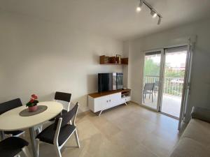 een woonkamer met een tafel en stoelen en een keuken bij Seaside Dreams in Santa Pola