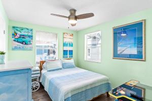a bedroom with a bed and a ceiling fan at Canary Beach Cottage in Clearwater Beach